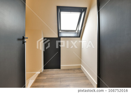 an empty room with wooden floors and skylights on the roof window is visible in the corner to the left 108752016