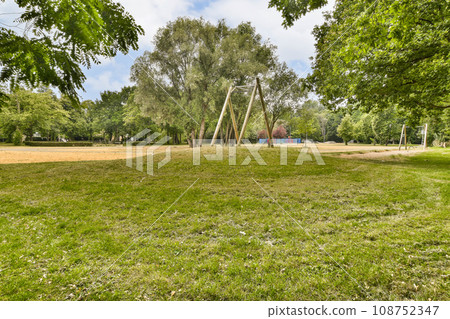 an empty park with trees and grass in the fore - image was taken from google street, south london stock photo 108752347