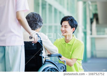 Elderly people in wheelchairs and young helpers who care 108752752