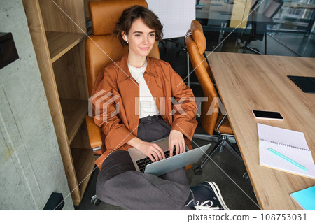Portrait of smiling young woman, manager works in office, uses laptop, works from co-working space 108753031