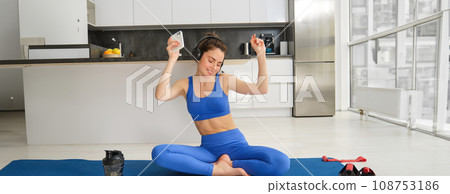 Dancing happy woman, workout from home on rubber yoga mat, having fun while training alone indoors with music Dancing happy woman, workout from home on rubber yoga mat, having fun while training alone indoors with music 108753186