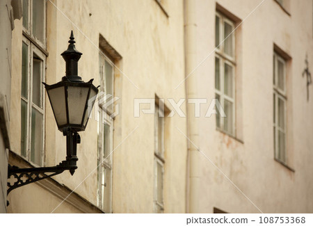 An antique street lamp on the wall of a house in the city. Photo 108753368