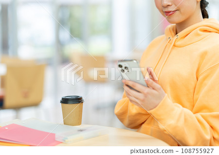 一名女大學生正在操作智慧型手機。攝影合作：有明教育藝術專門學校 108755927