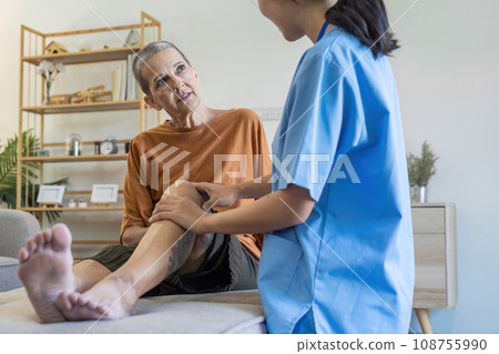 Elderly women have knee pain from osteoarthritis and have their symptoms examine by doctor for physiotherapy 108755990