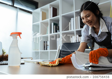 Woman maid cleaning and wiping the table with microfiber cloth in office Woman maid cleaning and wiping the table with microfiber cloth in office 108756438