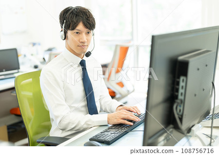 Male operator working with a headset on 108756716