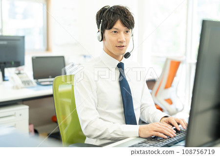Male operator working with a headset on Male operator working with a headset on 108756719