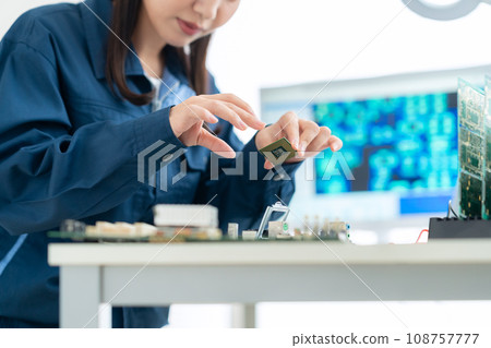 Young female engineer inspecting the board Young female engineer inspecting the board 108757777