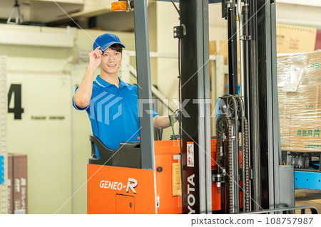 A man driving a forklift in a warehouse 108757987