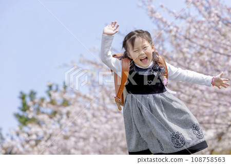 背著書包的一年級學生走過櫻花盛開的公園 108758563