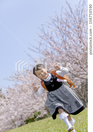 背著書包的一年級學生走過櫻花盛開的公園 108758590