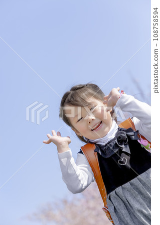 背著書包的一年級學生走過櫻花盛開的公園 108758594