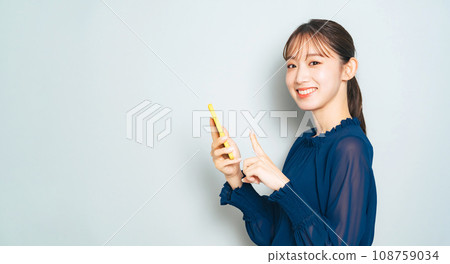 A woman using a smartphone A woman using a smartphone 108759034