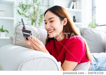 Young asian woman lying on sofa in living room Young asian woman lying on sofa in living room 108761530