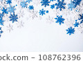 Christmas white background top view overhead with blue and white snowflakes. Copy space at the bottom 108762396