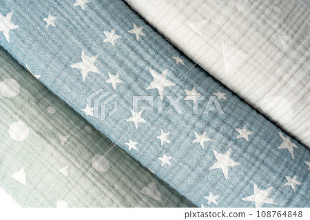 Three rolled muslin blankets on white backgorund 108764848