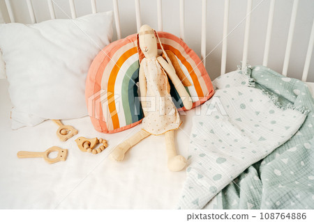Wooden white baby crib and toy rabbit close up Wooden white baby crib and toy rabbit close up 108764886