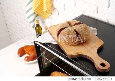 Freshly baked bread in mini oven in the kitchen Freshly baked bread in mini oven in the kitchen 108764904