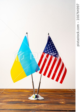 Small flags of USA and Ukraine on flagpoles close up 108764997