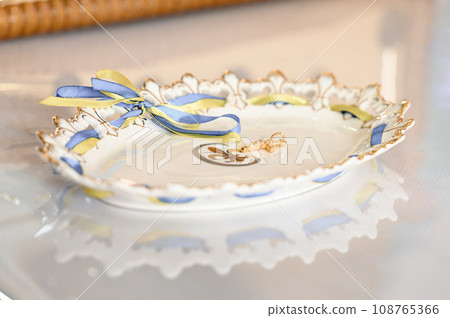 A golden cross lies on a tray in the church, candles are nearby, Christian rites in the church. 108765366