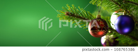 Christmas composition. Balls on a Christmas tree close-up on a green background Christmas composition. Balls on a Christmas tree close-up on a green background 108765386