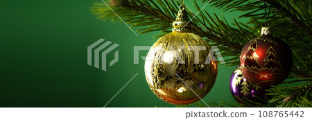 Christmas composition. Balls on a Christmas tree close-up on a green background Christmas composition. Balls on a Christmas tree close-up on a green background 108765442