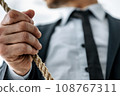 Businessman's right hand grasping the rope 108767311