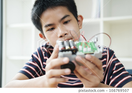 Asian teenager doing robot project in science classroom. technology of robotics programing and STEM education concept. 108769507