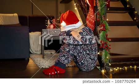 Little upset boy got sad and started crying while waiting for Santa on Christmas eve. Sadness, depression, solitude and negative emotions on winter holidays and New Year. Little upset boy got sad and started crying while waiting for Santa on Christmas eve. Sadness, depression, solitude and negative emotions on winter holidays and New Year. 108770204