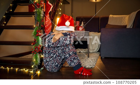 Portrait of crying boy sitting on floor on Christmas being left alone. Portrait of crying boy sitting on floor on Christmas being left alone. 108770205