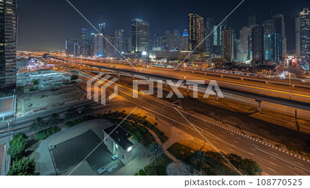 Panorama showing Dubai marina tallest block of skyscrapers night timelapse. 108770525
