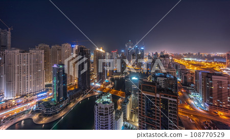 Panorama of various skyscrapers in tallest recidential block in Dubai Marina aerial all night timelapse 108770529