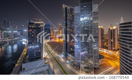 Panorama showing cityscape of skyscrapers in Dubai Business Bay with water canal aerial night timelapse Panorama showing cityscape of skyscrapers in Dubai Business Bay with water canal aerial night timelapse 108770540