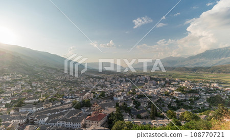 Panorama showing sunset over Gjirokastra city from the viewpoint of the fortress of the Ottoman castle of Gjirokaster timelapse. 108770721