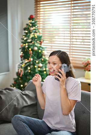 Happy caucasian woman in casual clothes having pleasant phone conversation while sitting on couch 108770791
