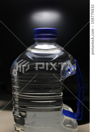 Huge plastic bottle with drinking water on a black background Huge plastic bottle with drinking water on a black background 108770832