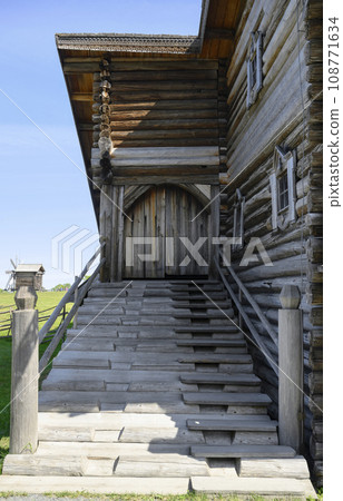 19-century wooden house with high porch and carved window frames on Kizhi Island in Karelia 19-century wooden house with high porch and carved window frames on Kizhi Island in Karelia 108771634