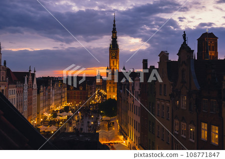 Beautiful old town in Gdansk at summer dusk Poland. Sunset night view from the window rooftop on historical centre Dluga street and city hall architecture buildings St Mary Basilica. Travel attraction Beautiful old town in Gdansk at summer dusk Poland. Sunset night view from the window rooftop on historical centre Dluga street and city hall architecture buildings St Mary Basilica. Travel attraction 108771847