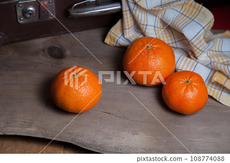 Ripe and juicy mandarins or tangerines on wooden board. 108774088