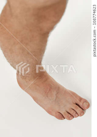 Barefoot male legs on white background. Body care concept. 108774623