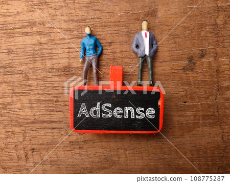 Wooden board and miniature people with text AdSense on a wooden background. 108775287