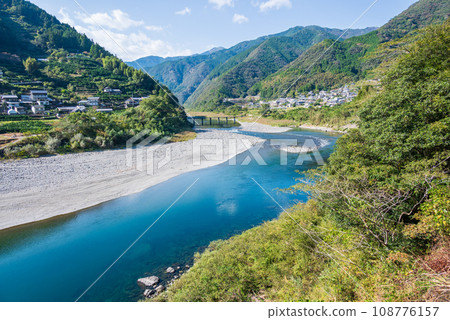 The settlement bridge over the clear stream of the Niyodo River 108776157