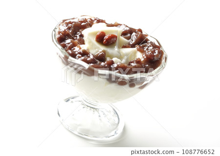 A photo of plenty of red bean paste and almond tofu served in a dessert cup against a white background 108776652