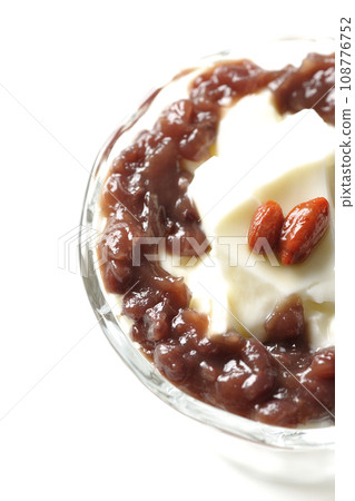 An overhead shot of plenty of red bean paste and almond tofu served in a dessert cup against a white background 108776752
