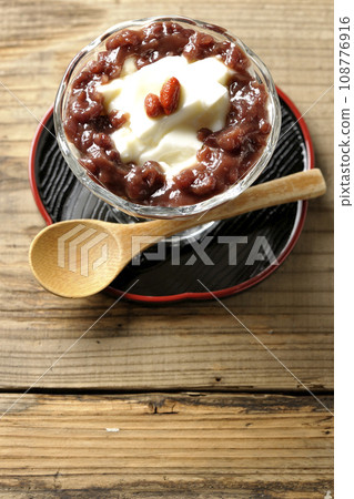 An overhead shot of plenty of red bean paste and almond tofu served in a dessert cup 108776916