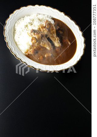 黑色背景下的熱咖哩飯和帶骨雞肉的頭頂照片 108777351