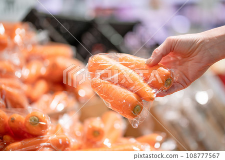 Woman's hand choosing carrots in supermarket 108777567