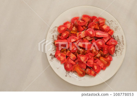 Tomatoes in a clay plate n beige background. Red sliced tomatoes in rustic beige bowl. Tomatoes in a clay plate n beige background. Red sliced tomatoes in rustic beige bowl. 108778053