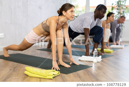 Young woman doing pilates in group in studio 108778129