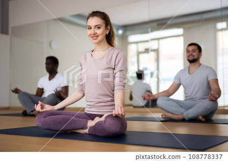 Woman sitting in Padmasana with hands on knees in mudra Woman sitting in Padmasana with hands on knees in mudra 108778337